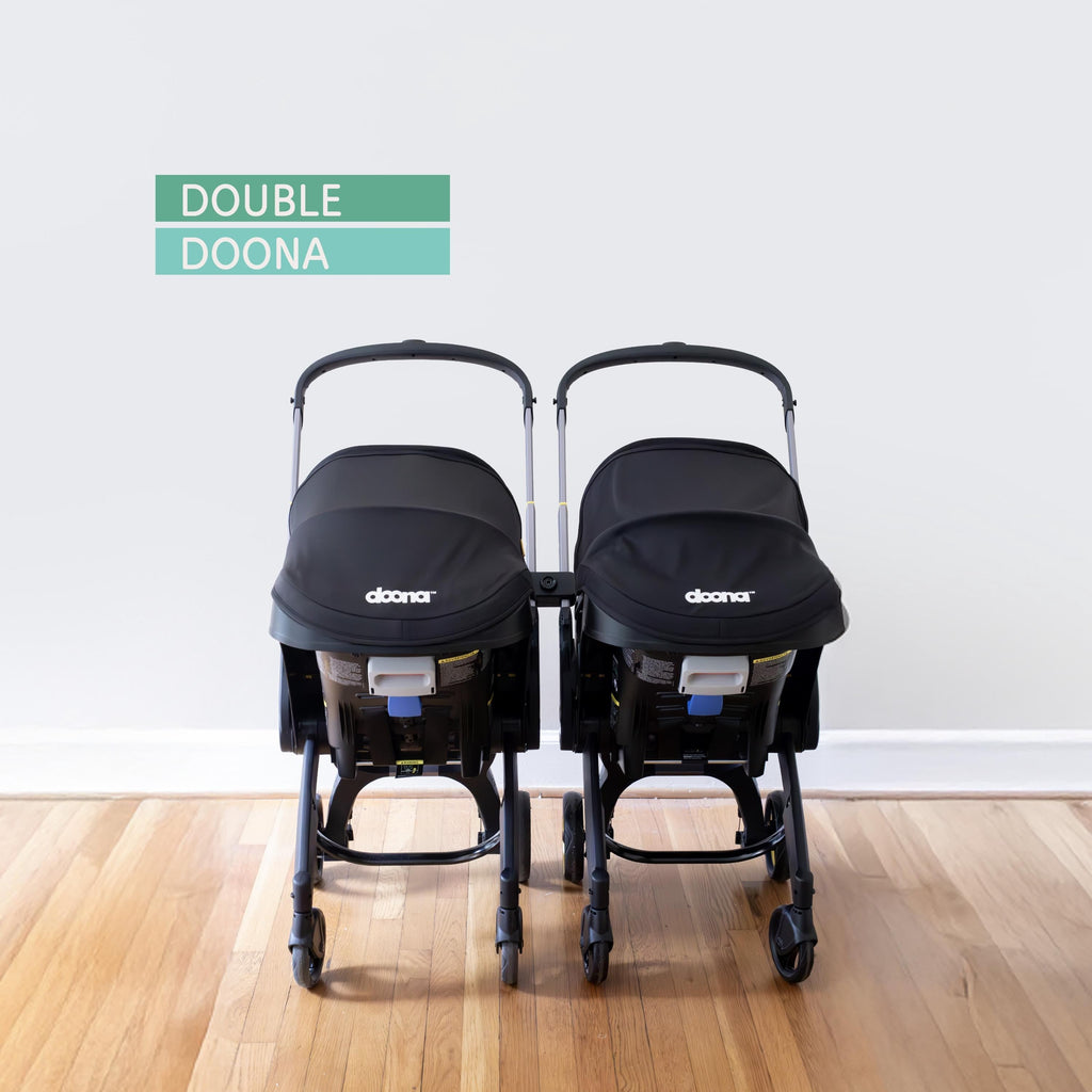 Two Doona car seat and strollers connected to each other using Vamos Baby connector